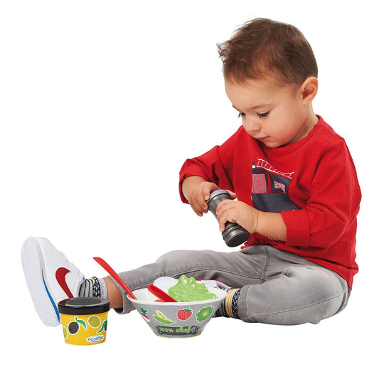 toddler playing with playfood salad set 