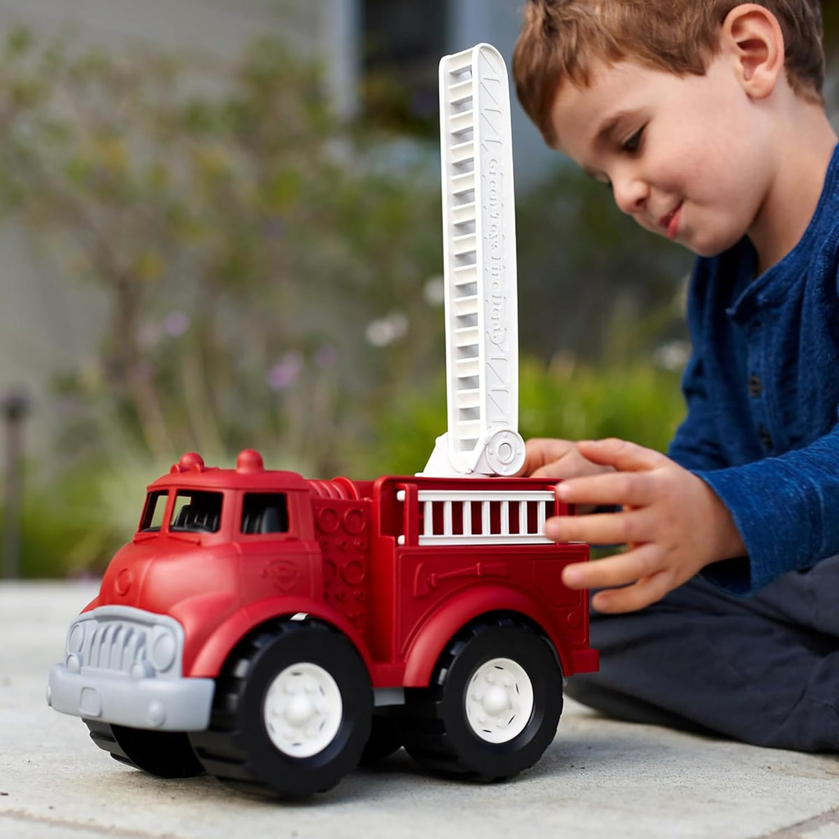 boy playing with ladder attachment of fire truck 