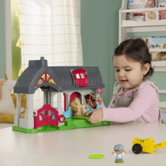 young girl playing with stable playset and accessories 