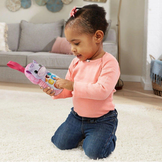 child playing with pink hippo phone 