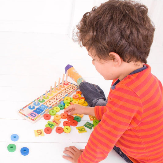 toddler playing with colourful wooden counting toy 