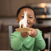 young boy holding llama figure 