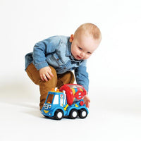 baby playing with toy cement mixer on  a white background