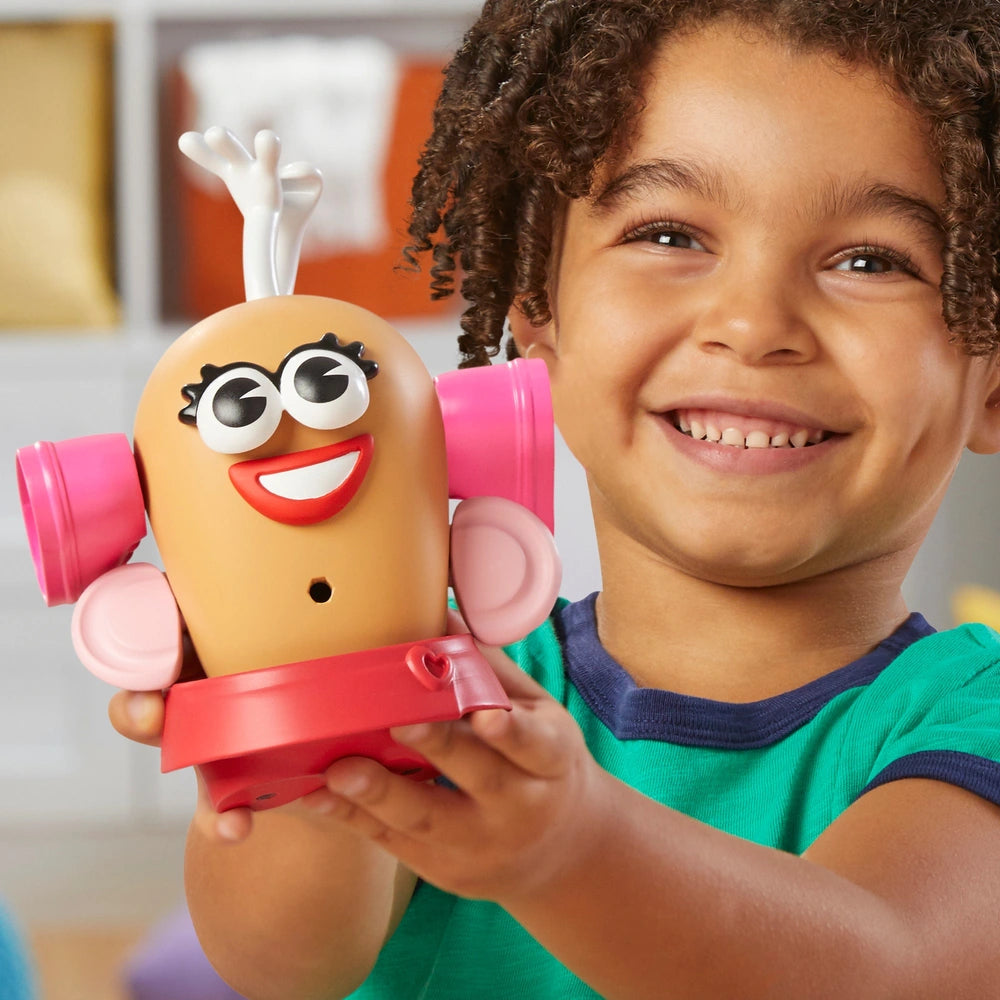 boy holding mismatched mrs potato head 