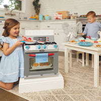 girl and boy playing with toy oven