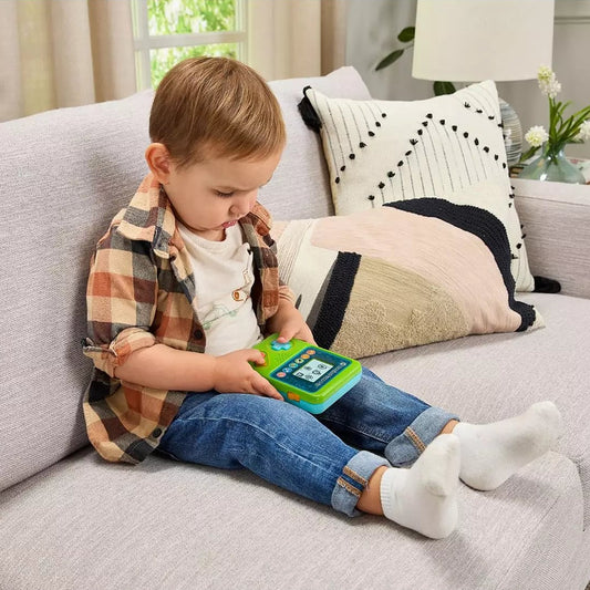 boy playing with preschool gaming console on a couch