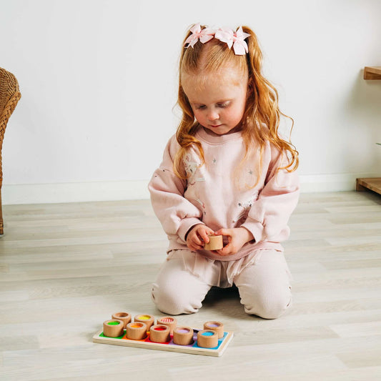 girl playing with wooden sensory board 