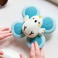 small hands holding a white bird spinner on a white surface 