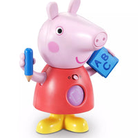 plastic peppa pig holding blue pencil and blue book on white background