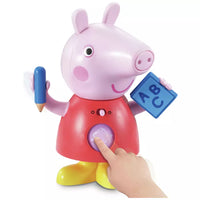 plastic peppa pig holding blue pencil and blue book on white background woth small hand coming towards it 