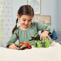 Young girl playing with green dinosaur and red motorbike on sofa 