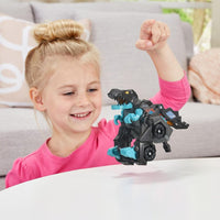 young girl playing with black and blue plastic dinosaur on white background