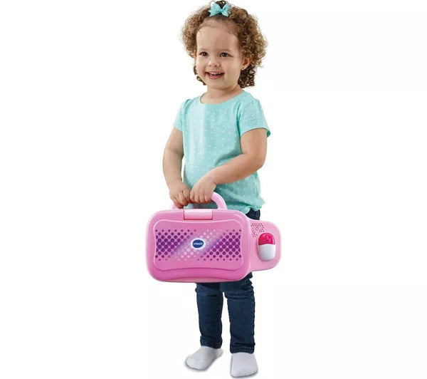 toddler standing holding pink toy laptop on white background 