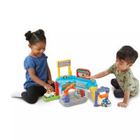 two toddlers playing with colourful driver repair playset on white background 