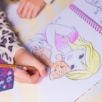 girl colouring in girl holding lion page of colouring book 