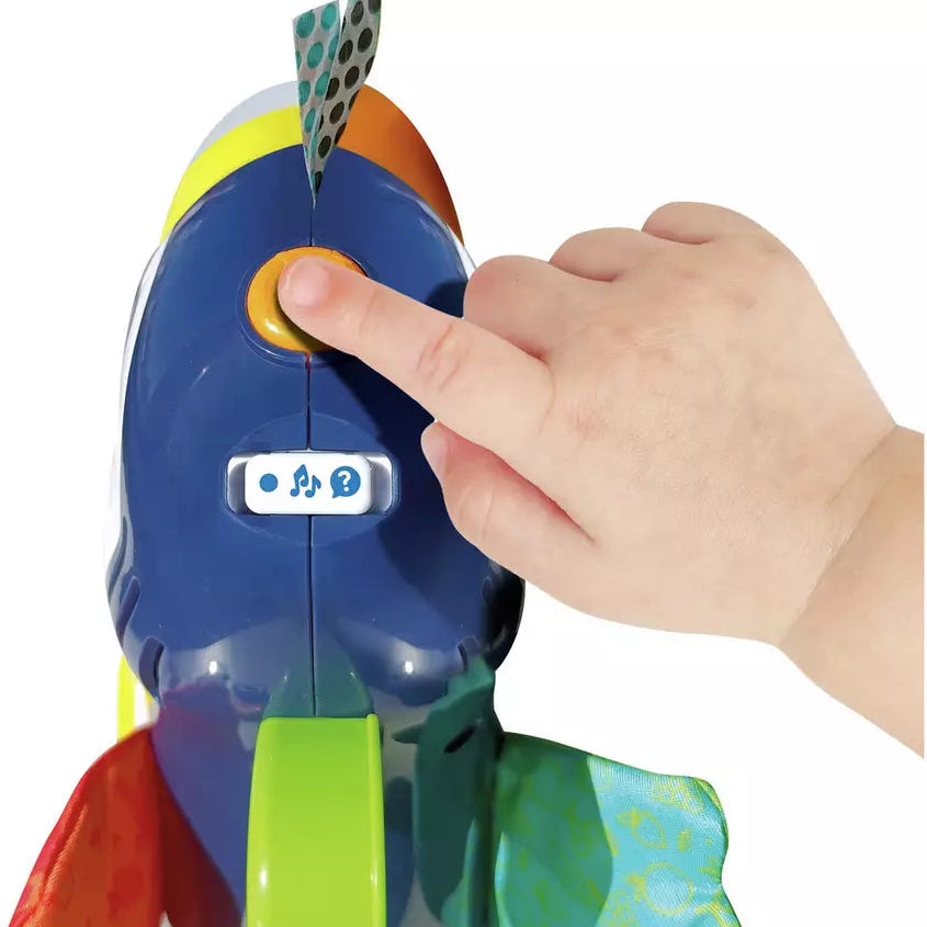 baby hand pressing button on toy toucan head 