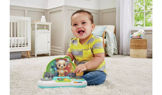 baby playing with brightly coloured children's toy on carpet 