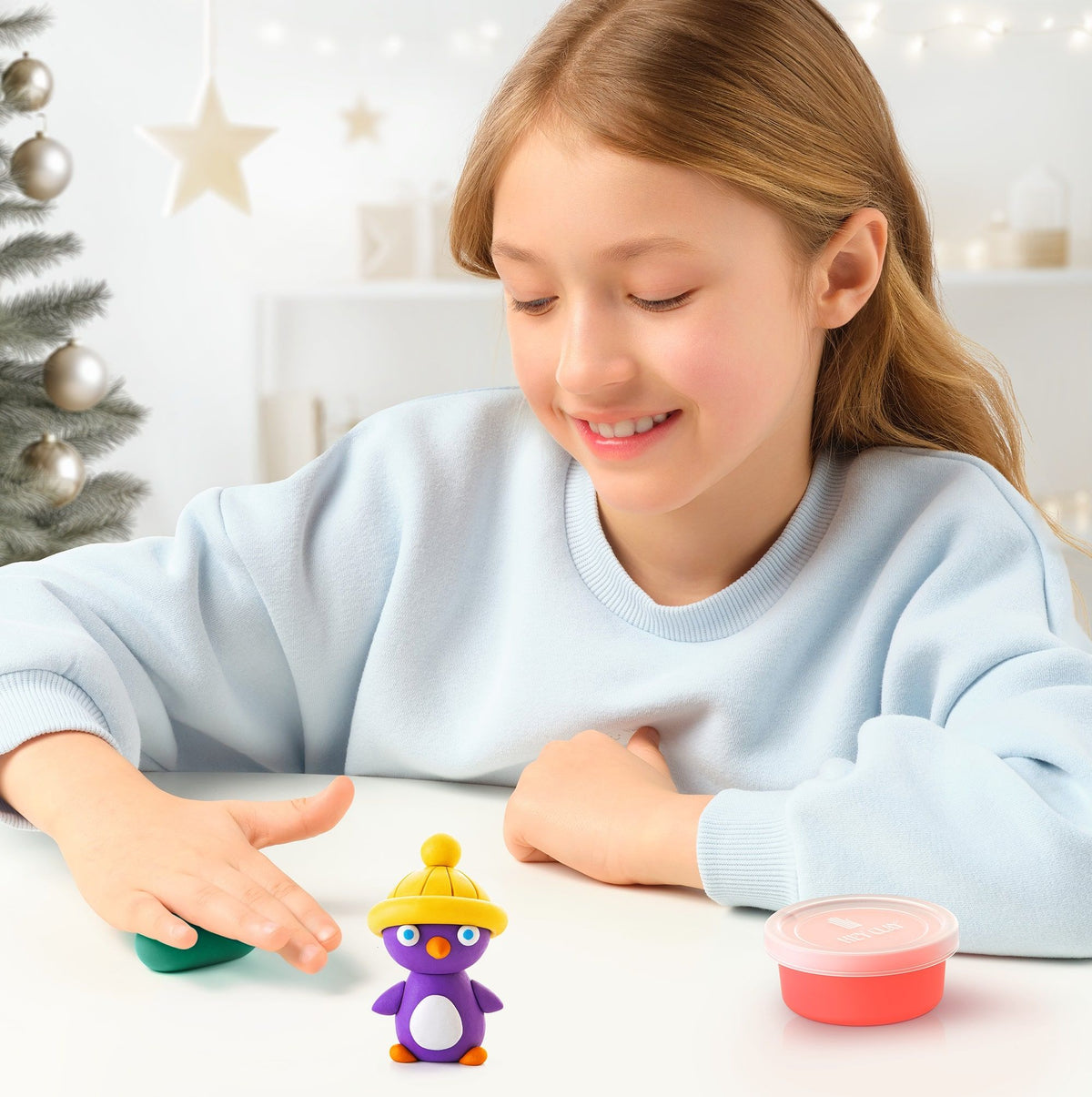 girl making purple clay penguin 