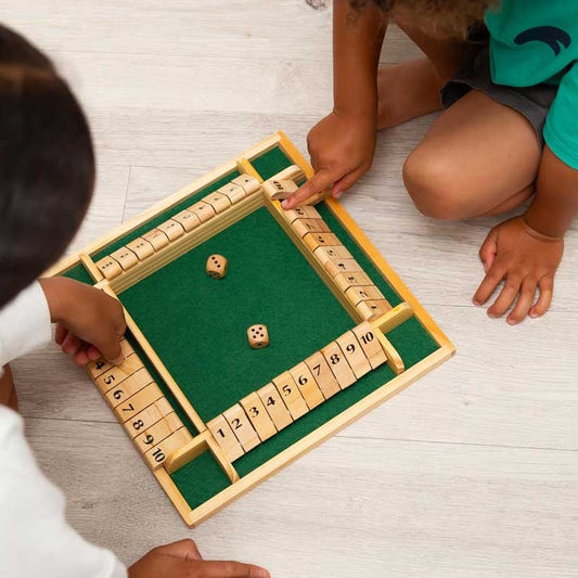children playing wooden shut the box game