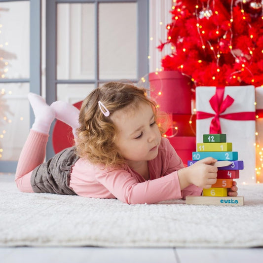 child playing with wooden construction clock 