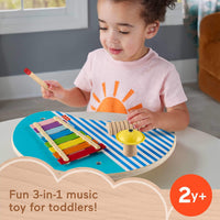 toddler playing with wooden music table 