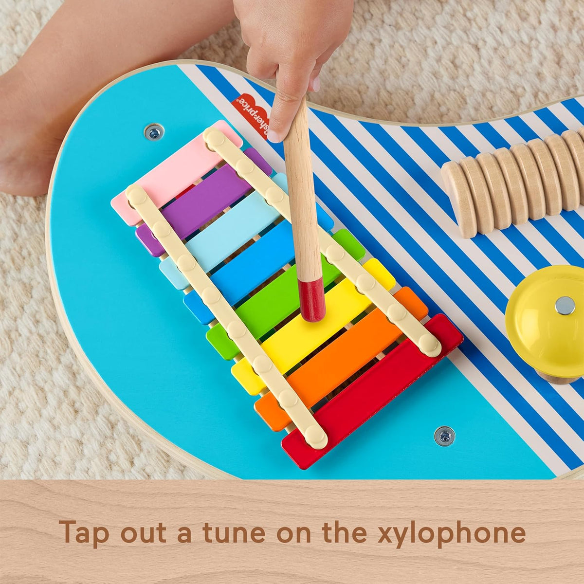 toddler playing xylophone on wooden music set 