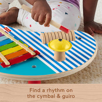 toddler playing cymbal on wooden music table 