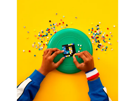 Kid adding LEGO DOTS tiles to a wearable accessory.