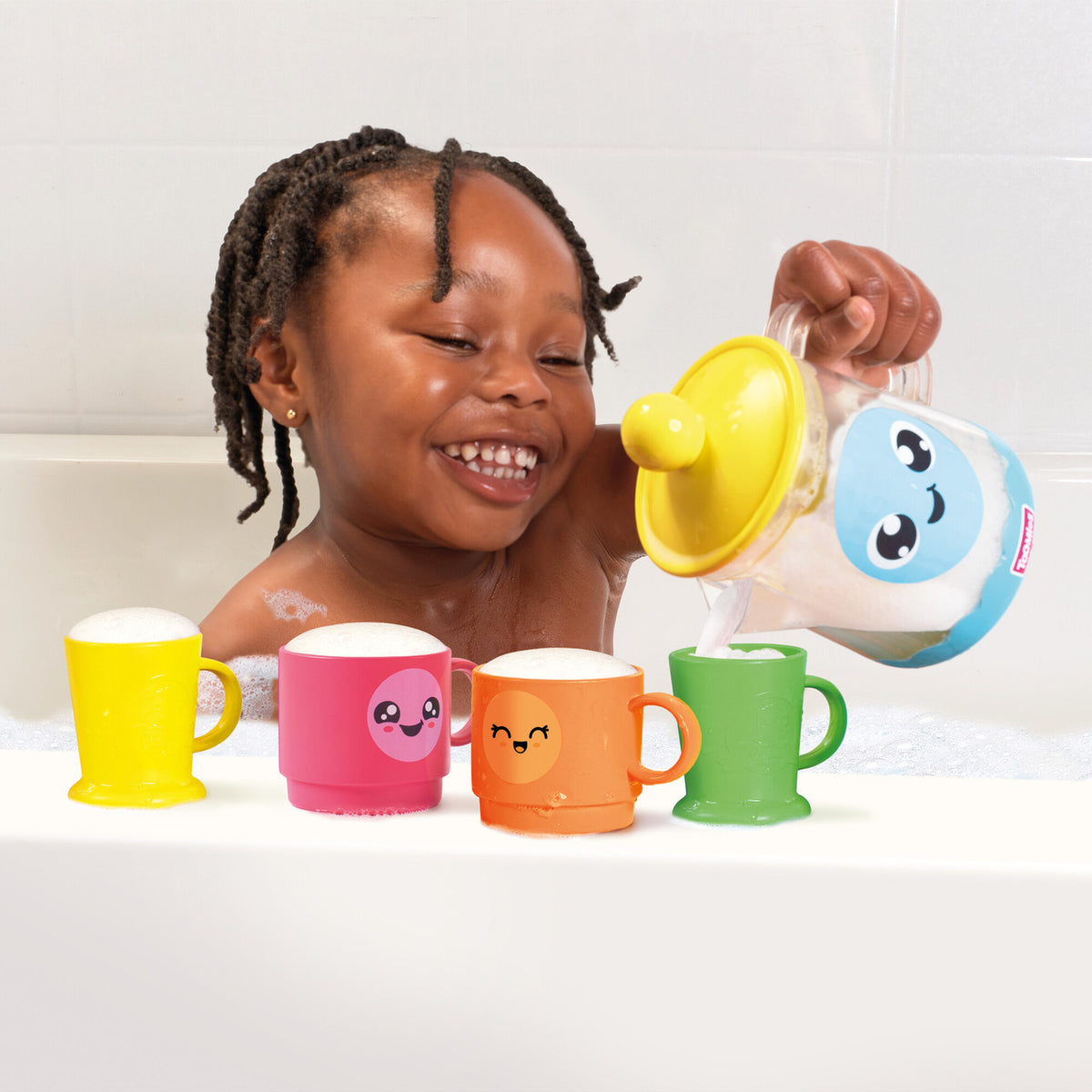 Child pouring bubbly water from the Tomy Bubble & Brew Bath Set teapot into colourful cups.